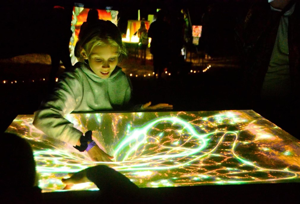 Child interacting with the Nocturna touchscreen installation